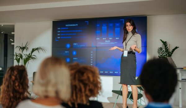 Executive leading an AI workforce transformation workshop with employees reviewing digital transformation initiatives.