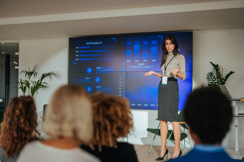 Executive leading an AI workforce transformation workshop with employees reviewing digital transformation initiatives.